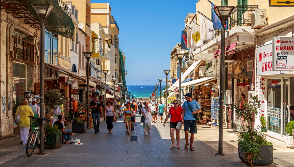 Прогуливающиеся по одной из улиц города люди в Греции Греческий город